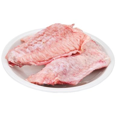 Två stycken råa köttbitar liggande på en vit tallrik.
